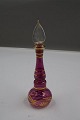Elegant perfume bottle of purple glass with cork and gold decoration